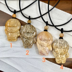 May include: Four necklaces with brown and beige stone pendants shaped like a cartoon character. The pendants are numbered 1 through 4.