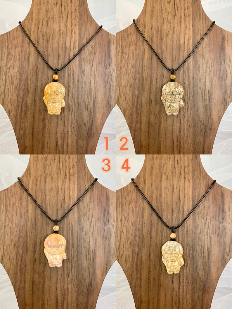 May include: Four necklaces with a wooden pendant in the shape of a cartoon character. The necklaces have black cords and the pendants are a light brown colour.