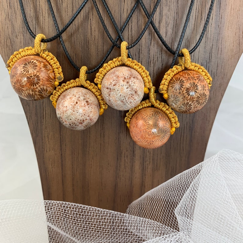 Puede incluir: Cinco collares con cord&oacute;n dorado y un colgante redondo de coral fosilizado de color marr&oacute;n claro. Cada colgante tiene un patr&oacute;n &uacute;nico.