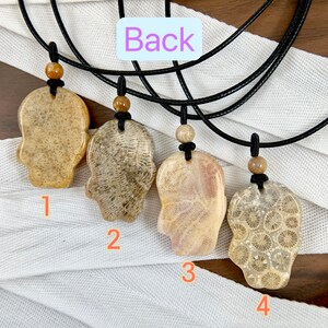 May include: Four fossilised coral pendants on black cords with wooden beads. The pendants are in the shape of a hand with intricate patterns. The pendants are numbered 1 through 4.