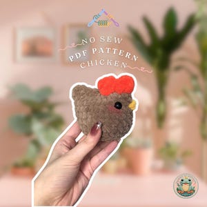 May include: A brown and orange crocheted chicken toy with a red comb and yellow beak. The toy is being held in a hand. The text "NO SEW PDF PATTERN CHICKEN" is visible in the background.