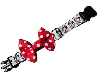 Może przedstawiać: Obroża dla psa z czerwoną kokardą w białe grochy. Obroża jest biała ze wzorem twarzy Myszki Minnie. Obroża ma czarną plastikową klamrę i metalowe okucia.