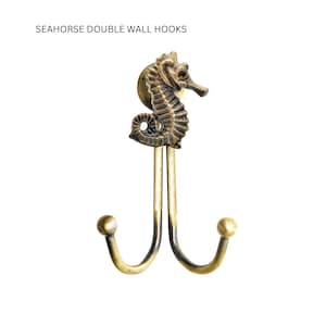 May include: Bronze seahorse double wall hooks. The hooks feature a detailed seahorse design at the top, with two curved hooks below. The text "SEAHORSE DOUBLE WALL HOOKS" is at the top. The hooks are made of metal.