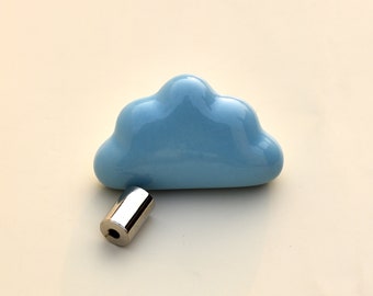 May include: A light blue cloud-shaped ceramic knob with a shiny silver metal cylindrical pull. The knob is a whimsical design element for furniture or decor, adding a touch of playfulness. The hardware is suitable for drawers or cabinets.
