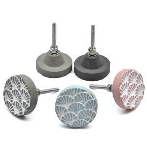 May include: A collection of five decorative cabinet knobs. Two are solid gray and dark gray, while the other three are round with a fan-shaped pattern in gray, light blue, and pink. Each knob has a silver screw for installation.