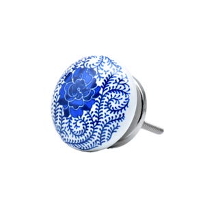 May include: A white and blue ceramic cabinet knob with a floral design. The knob features a blue flower in the center, surrounded by blue leaf patterns. The knob has a silver metal base and screw.