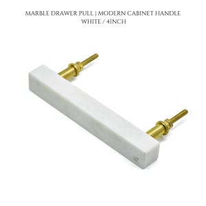 May include: White marble drawer pull with brass hardware. The rectangular handle is 4 inches long. The text on the image reads: MARBLE DRAWER PULL | MODERN CABINET HANDLE WHITE / 4INCH.