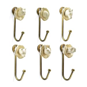 Puede incluir: Seis ganchos decorativos de pared con diseños de cabeza de animal. Cada gancho presenta una cabeza de animal de cerámica color crema, incluyendo un oso, un caballo y un conejo, sobre un gancho de metal dorado. Los ganchos están montados sobre un fondo blanco.