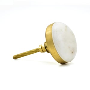 Può includere: Un pomello per mobili in marmo bianco con base e vite color oro. Il pomello è rotondo e ha una finitura lucida. La vite è filettata e di colore ottone.