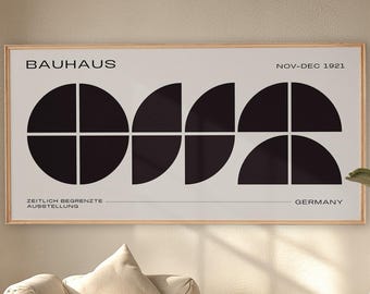 Peut inclure: Une affiche encadrée de style Bauhaus avec un motif géométrique noir sur fond crème. L'impression comprend le mot "Bauhaus", les dates "NOV-DEC 1921" et le mot "GERMANY". L'œuvre est affichée au-dessus d'un canapé beige.
