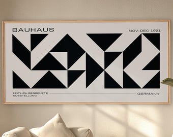Peut inclure: Une affiche encadrée Bauhaus avec un motif géométrique noir et blanc. L'affiche comprend le texte "BAUHAUS" en haut, avec du texte supplémentaire indiquant les dates et le lieu de l'exposition. L'affiche est affichée au-dessus d'un canapé beige et d'une table basse en bois.