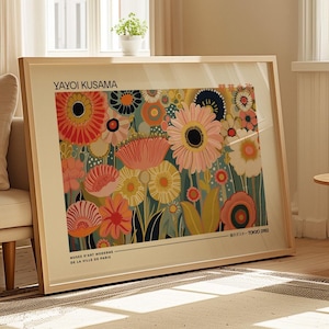 May include: A framed art print featuring a floral pattern by Yayoi Kusama with vibrant red, orange, pink, yellow, and dark blue stylized flowers on a cream background. The text reads Yayoi Kusama, Musee d'Art Moderne de la Ville de Paris, and Tokyo 1982.