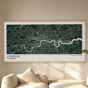 May include: A rectangular wall art print featuring a dark green map of London with white street lines and the River Thames. The print includes the text LONDON, UNITED KINGDOM, and coordinates 51 30 28 N, 0 07 39 W in a light wooden frame.