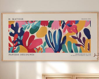 May include: A rectangular wall art print in a light wood frame featuring an abstract H. Matisse Papiers Découpés design. The artwork displays organic, colorful shapes in red, blue, yellow, pink, and green against a cream background with text.