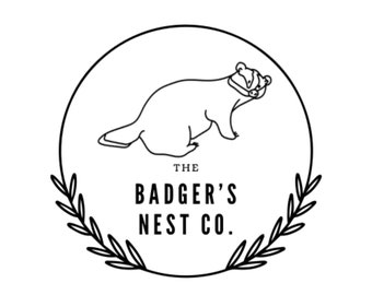 Può includere: Illustrazione in bianco e nero di un tasso all'interno di un cerchio con foglie intorno all'esterno. Il testo "THE BADGER'S NEST CO." è sotto il tasso.