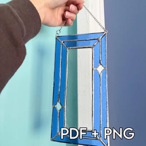 Pode incluir: Um painel de vitral retangular com segmentos de vidro azul vibrante unidos por linhas de solda de metal prateado. O design inclui um espaço retangular central aberto e quatro pequenos detalhes em forma de diamante. Texto: PDF + PNG Pattern.