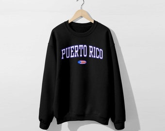 Könnte beinhalten: Schwarzer Pullover mit einem weißen Umriss des Textes "PUERTO RICO" und einer kleinen Grafik der puerto-ricanischen Flagge.