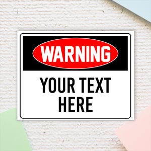 May include: A white warning sign with a black border and a red oval containing the word "WARNING" in white text. The sign also has the text "YOUR TEXT HERE" in black.
