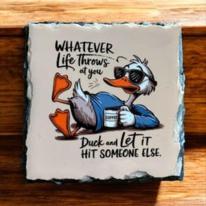 May include: Square stone coaster with a cartoon duck wearing sunglasses and holding a coffee cup. The text reads "Whatever Life Throws at You, Duck and Let It Hit Someone Else."