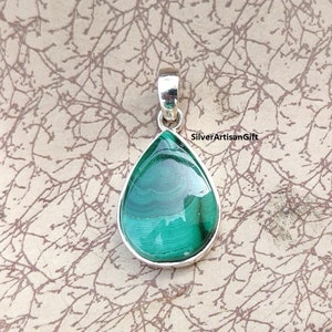May include: A teardrop-shaped pendant with a polished malachite stone set in a silver bezel. The malachite displays a rich green color with swirling patterns. The pendant has a silver bail for a chain.