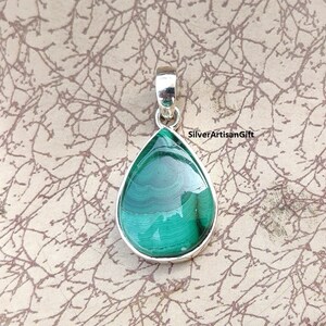 May include: A teardrop-shaped pendant with a polished malachite stone set in a silver bezel. The malachite displays a rich green color with swirling patterns. The pendant has a silver bail for a chain.