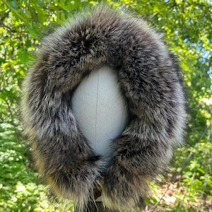 May include: A brown and gray fur collar with a soft, fluffy texture. The collar is displayed on a white mannequin head.