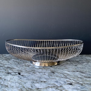 May include: A handmade, wooden serving tray with a natural finish. The tray features a rectangular shape with rounded corners and raised edges. It is designed with two handles for easy carrying. The wood grain is visible, adding to its rustic charm.