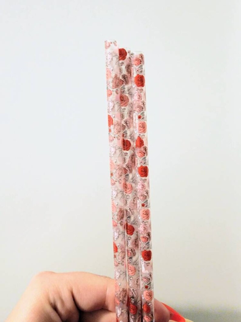 Pu&ograve; includere: Set di tre cannucce di plastica trasparente con un motivo floreale in tonalit&agrave; rosa e rosso.