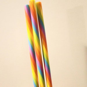 Pu&ograve; includere: Tre cannucce da bere a righe arcobaleno. Le cannucce sono gialle, arancioni, rosse, viola, blu e verdi.