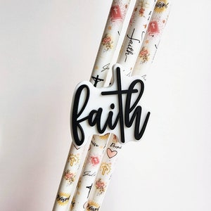Pu&ograve; includere: Tre cannucce bianche con un design floreale e religioso. Le cannucce hanno un motivo ripetitivo di croci, cuori e le parole "Blessed", "Faith" e "Promise". Le cannucce sono sormontate da un cartello bianco e nero che dice "faith".