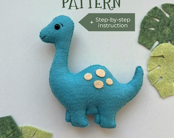 May include: A turquoise felt dinosaur with tan spots and black eyes. The image includes the text "PDF PATTERN" and "Step-by-step instruction". Green felt leaf cutouts are scattered around the dinosaur.