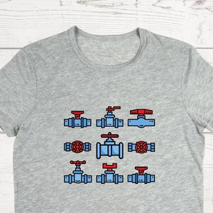 May include: A gray t-shirt with a design of various blue and red plumbing valves.