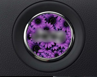 May include: A purple flower car air freshener with a chrome ring around the edge.