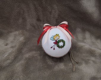 A Christmas ball with a fairy holding a wreath