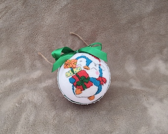 Christmas ornament featuring a penguin carrying many gifts