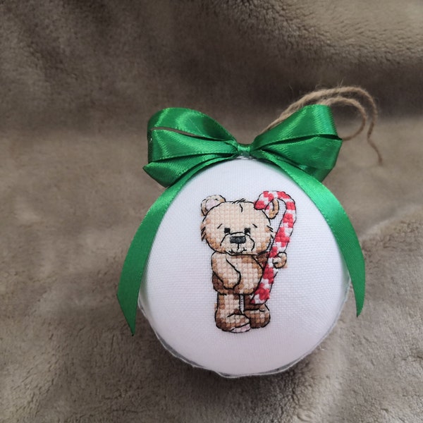 A New Year's ball with a cute bear holding candy in its paws