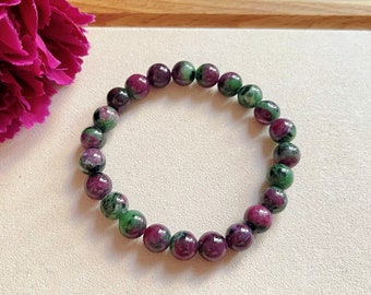 May include: A green and pink gemstone bracelet with round beads. The bracelet is made of natural stones and is a beautiful piece of jewelry.