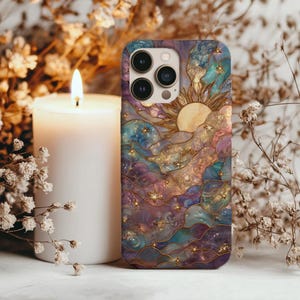 Puede incluir: Funda de tel&eacute;fono con un dise&ntilde;o celestial que presenta un sol, estrellas y nubes en tonos azules, morados y dorados. La funda tiene un acabado brillante y un dise&ntilde;o en relieve. Hay una vela blanca al lado.