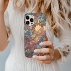 Puede incluir: Funda de tel&eacute;fono inteligente con un dise&ntilde;o celestial. Presenta un sol, nubes y estrellas en tonos azules, morados y dorados. La funda tiene un acabado brillante y una est&eacute;tica art&iacute;stica detallada.