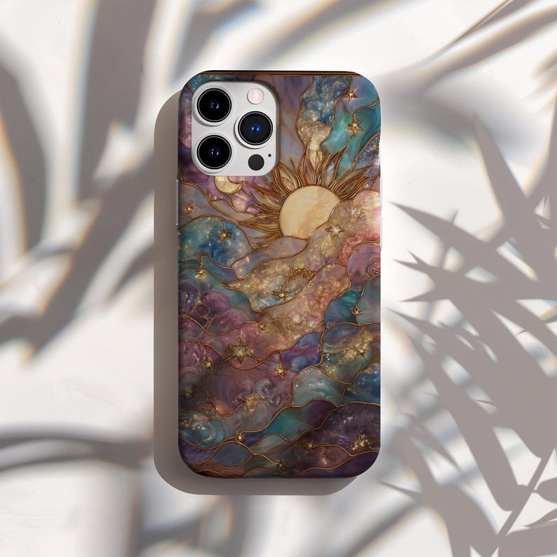 Puede incluir: Una funda para smartphone con un dise&ntilde;o celestial que presenta un sol, nubes y estrellas. La funda tiene un efecto de vidriera de colores con tonos de morado, azul y dorado. La funda tiene un acabado brillante y un parachoques protector en los bordes.