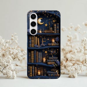 May include: A navy blue phone case featuring a detailed bookshelf design. The shelves are filled with antique books, candles, and floral accents. A gold crescent moon and stars adorn the top, creating a whimsical, fantasy theme.
