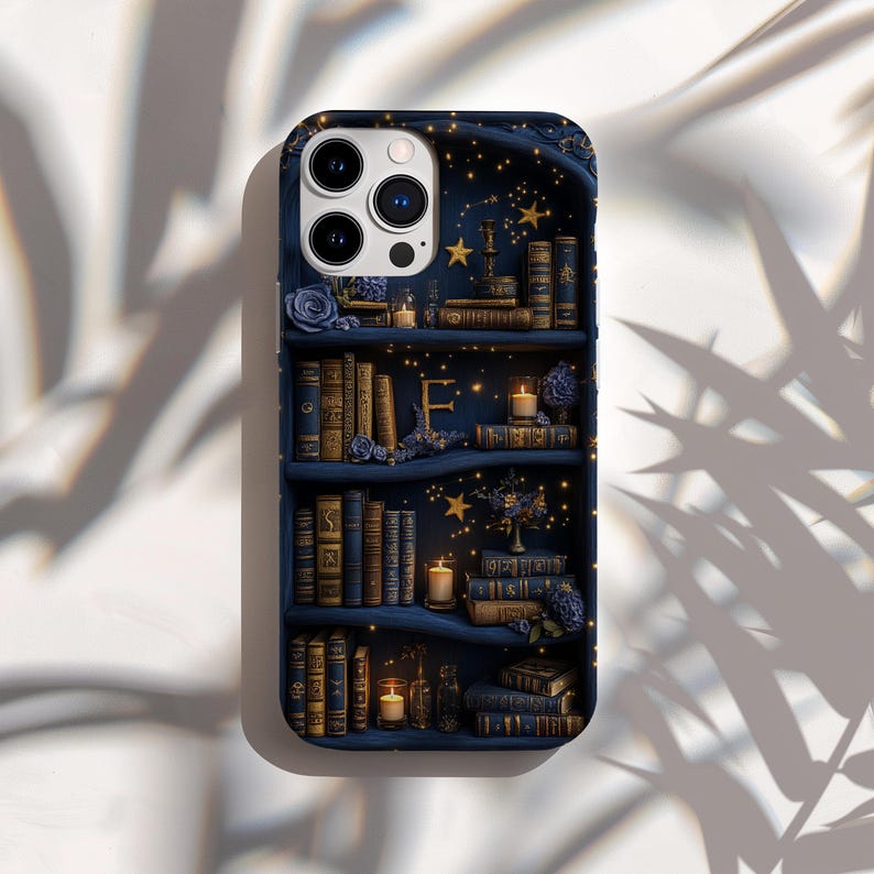 May include: A navy blue phone case featuring a detailed illustration of a bookshelf. The design includes stacks of antique books, candles, and floral accents. The background is a starry night sky with golden stars.