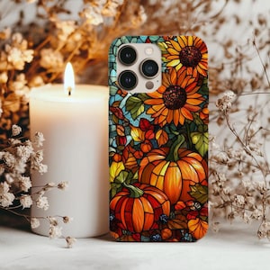 Op de afbeelding: Een kleurrijke telefoonhoes met een glas-in-lood ontwerp van pompoenen, zonnebloemen en herfstbladeren in oranje, geel en groen. De hoes heeft een glanzende afwerking en een zwarte cameramodule.