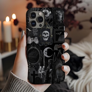Puede incluir: Funda de teléfono negra con un diseño de collage gótico. El diseño incluye ilustraciones de una calavera, fantasmas, una luna creciente, una iglesia y una lápida. La funda tiene un acabado mate y una estética oscura.