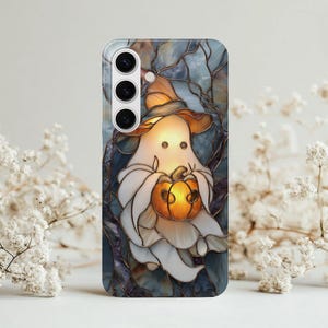 Puede incluir: Funda de teléfono con un diseño de vidriera de un fantasma amistoso con un sombrero de bruja y sosteniendo una calabaza brillante. El fondo tiene un patrón de árbol azul y gris, perfecto para Halloween.