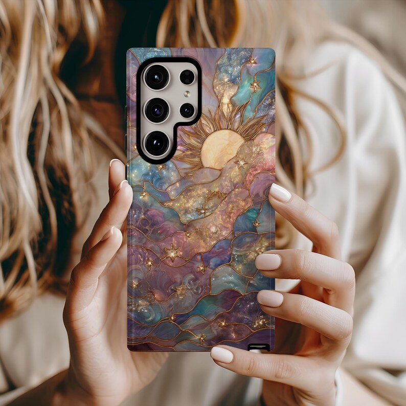 Puede incluir: Funda de tel&eacute;fono colorida con un dise&ntilde;o de vidriera que presenta un sol, estrellas y nubes arremolinadas en tonos morados, azules y dorados. La funda tiene un acabado brillante.