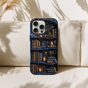 May include: A navy blue phone case featuring a bookshelf design with books, candles, and floral accents. The letter "F" is visible on the middle shelf. The case has a glossy finish and a dark blue border.