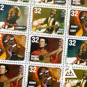 May include: A sheet of vintage postage stamps featuring portraits of folk musicians. Each stamp has a "32" value and the text "USA." Musicians include Leadbelly, Woody Guthrie, Josh White, and Sonny Terry. The stamps are in shades of green, brown, and red.