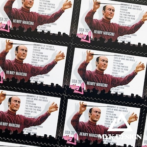 May include: Sheet of postage stamps featuring Henry Mancini, with the text "HENRY MANCINI" and "USA 37". The stamps have a black border and include text listing film titles. A pink cartoon panther is also visible.
