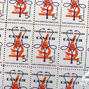 May include: A sheet of vintage United States postage stamps with a microscope and the text "Crusade Against Cancer" and "Early Diagnosis Saves Lives".